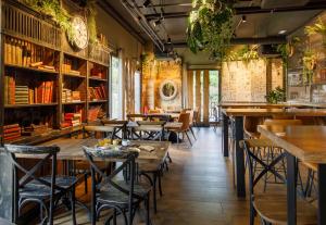 a restaurant with wooden tables and chairs and bookshelves at B&B HOTEL Clermont-Ferrand A71-A75 La Méridienne in Clermont-Ferrand