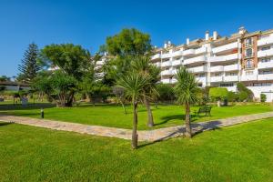 einen Park mit Palmen vor einem Gebäude in der Unterkunft C03 La Siesta 1 - Apartment in Sitio de Calahonda