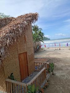 a small hut on the beach with the ocean at El Hermosa Beach Resort in El Nido