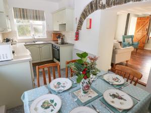 eine Küche und ein Esszimmer mit Tisch und Stühlen in der Unterkunft Barn Cottage in Spittal