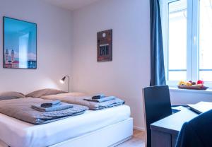 a bedroom with a bed with towels on it at HITrental Central Station Apartment in Zurich