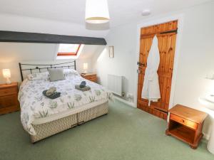 ein Schlafzimmer mit einem Bett und einem Waschbecken in der Unterkunft Barn Cottage in Spittal