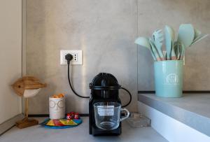 a black coffee maker sitting on a counter with a vase at Alice's Home - 20 Steps from the Sea in Riva Trigoso +14 photos