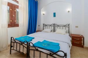 a bedroom with a bed with blue towels on it at Style Apartment in nubian design at lagoon in Hurghada +13 photos