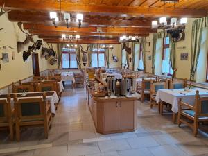 a restaurant with tables and chairs in a room at Odvaskő Panzió in Ugod