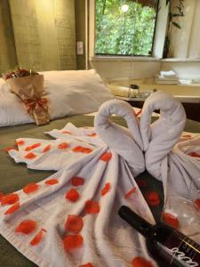 カンポス・ド・ジョルドンにあるLittle cabana com Hidromassagemのベッド1台(タオル2枚、ハート付)