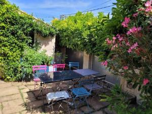 une table et des chaises dans un jardin fleuri dans l'établissement La Madeleine - Maison de Ville Moderne - Terrasse, à La Rochelle
