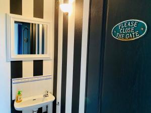 une salle de bain avec un lavabo et un panneau sur le mur dans l'établissement La Madeleine - Maison de Ville Moderne - Terrasse, à La Rochelle 45 autres photos