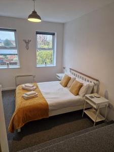 a bedroom with a large bed with towels on it at Hereford City - Victory Apartment - Modern Studio In Vibrant Popular Area of Hereford - Hosted by RENTMYHOUSE in Hereford