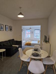 a living room with a couch and a table and chairs at Hereford City - Victory Apartment - Modern Studio In Vibrant Popular Area of Hereford - Hosted by RENTMYHOUSE in Hereford