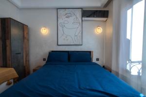 - une chambre dotée d'un lit bleu et d'une peinture murale dans l'établissement Cozy I Victor Hugo, à Marrakech