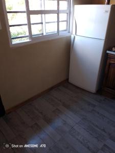 a white refrigerator in a room with a window at Lo de tina in Florencio Varela