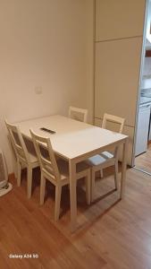 a table and chairs with a white table and a kitchen at Apartamentos Sierra in San Isidro +3 photos