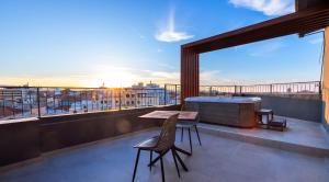 a balcony with a table and chairs on a building at Anele Luxury Suites - Roof Top Jacuzzi in Chania