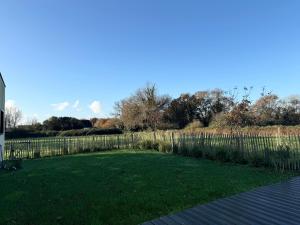 康布里特Lilas, maison de charme à Sainte Marine près de la mer的一个带栅栏和绿草的院子