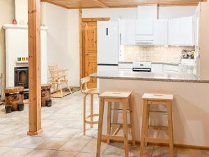 a kitchen with white cabinets and a counter with stools at Holiday Home Tahkontupa by Interhome in Tahkovuori