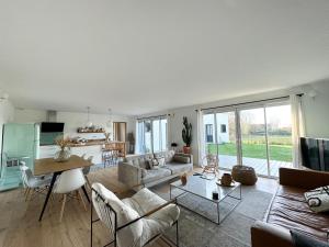 康布里特Lilas, maison de charme à Sainte Marine près de la mer的客厅里有一张沙发和一张桌子。