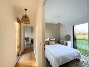 康布里特Lilas, maison de charme à Sainte Marine près de la mer的卧室里有一张白色的大床和一扇窗户