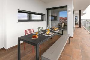 ein Esszimmer mit einem schwarzen Tisch und Bänken in der Unterkunft Consolação Sunset View in Atouguia da Baleia