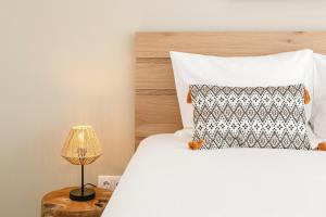 ein Schlafzimmer mit einem weißen Bett und einer Lampe in der Unterkunft Consolação Sunset View in Atouguia da Baleia + 18 Fotos