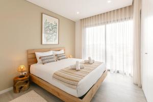 ein Schlafzimmer mit einem großen Bett und einem großen Fenster in der Unterkunft Consolação Sunset View in Atouguia da Baleia