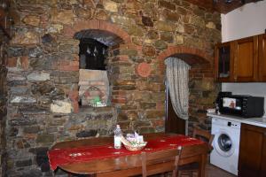 a kitchen with a table and a brick wall at Rabat home in Tursi