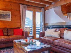 a living room with leather couches and a table at Chalet Crettamour by Interhome in Veysonnaz +41 photos