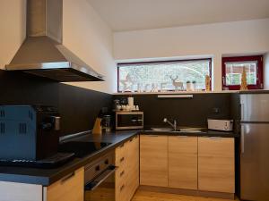 Una cocina con gabinetes de madera y un refrigerador de acero inoxidable. en Chalet Harrachov by Interhome, en Harrachov