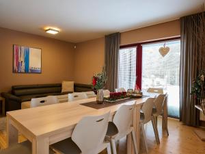 Un comedor con una mesa de madera y sillas blancas. en Chalet Harrachov by Interhome, en Harrachov