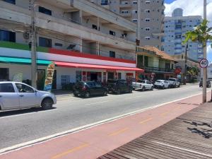 eine Straße mit am Straßenrand geparkten Autos in der Unterkunft Gostosa casa de praia, à 700 metros da Meia-Praia in Navegantes