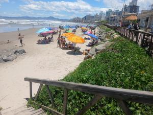 ein Strand mit Sonnenschirmen und Menschen auf dem Sand in der Unterkunft Gostosa casa de praia, à 700 metros da Meia-Praia in Navegantes + 81 Fotos