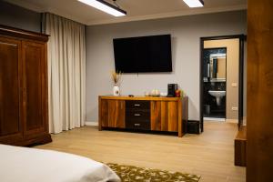 a bedroom with a flat screen tv on the wall at Therme Criss -Camera in Baloteşti