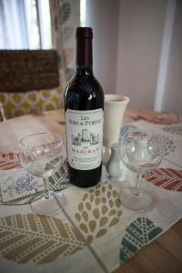 uma garrafa de vinho sentada numa mesa com dois copos em Moulin De Villesaint em Faux-la-Montagne
