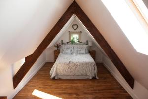a bedroom with a bed in a attic at Moulin De Villesaint in Faux-la-Montagne