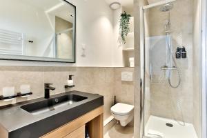 een badkamer met een wastafel, een toilet en een douche bij Marais Elegence Suites - Two bedrooms in Parijs +11 foto's