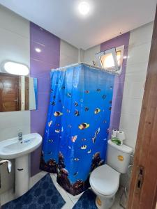 un baño con cortina de ducha con un pez. en Charming Two Bedroom Apartment in Fes Near City Center, en Fez