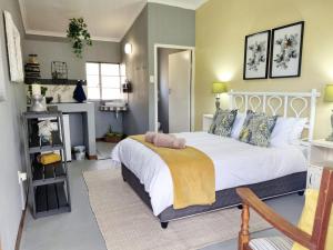 a bedroom with a white bed and a fireplace at Amanzi Farm Rooms in Montagu