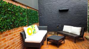 a patio with a couch and tables and a brick wall at Serenity home in the heart of city in Sydney
