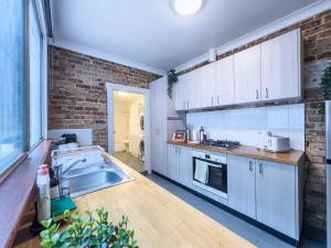 a kitchen with a sink and a brick wall at Serenity home in the heart of city in Sydney