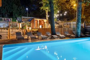 una piscina con sedie e una casa sullo sfondo di Apartament Larice VIP - sauna, balia, basen a Świeradów-Zdrój Altre 24 foto