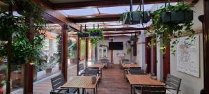 a restaurant with wooden tables and chairs and plants at UNAHOTELS Eco Hotel Villa Costanza Venezia in Mestre