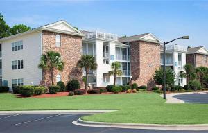 a large apartment building with a lawn in front of it at Sea Trail Golf Resort & Convention Center in Sunset Beach