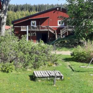 a red building with a bench in front of it at Stall Norrby in Norrby