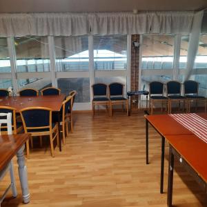 a dining room with tables and chairs and windows at Stall Norrby in Norrby