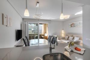 a kitchen with a sink and a living room at Las Arenas Atico by Ĥ - Playa de los Haraganes HLHA245P97 in Isla Canela