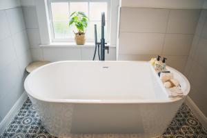 a white bath tub in a bathroom with a window at Charming 2-Bedroom home in Leamington Spa in Leamington Spa +30 photos