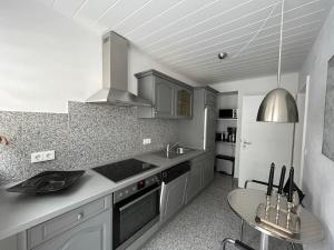 a kitchen with a sink and a stove top oven at Haus Arthur Klingels in Bad Bertrich +16 photos