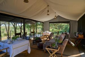 a tent with a table and chairs in it at Basecamp Wilderness in Naboisho