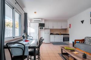une cuisine et un salon avec une table et des chaises dans l'établissement Apartamentos Julieta, à Albufeira