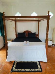 ein Schlafzimmer mit einem großen Bett mit Holzrahmen in der Unterkunft Bukit lawang in Bukit Lawang